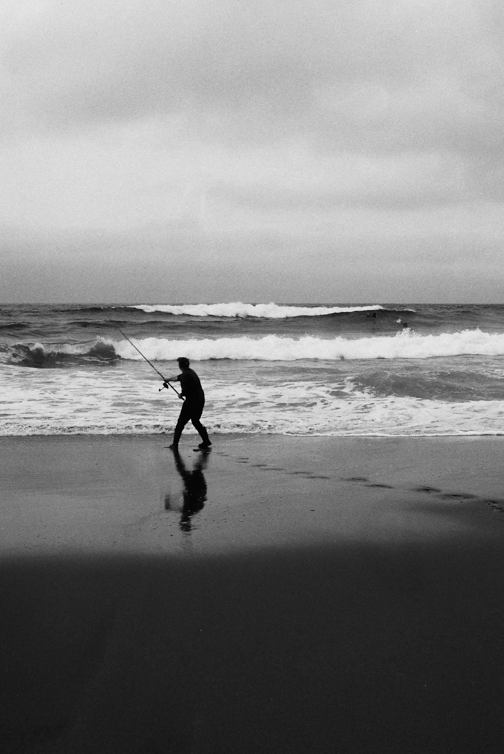 a person walking on a beach with a surfboard