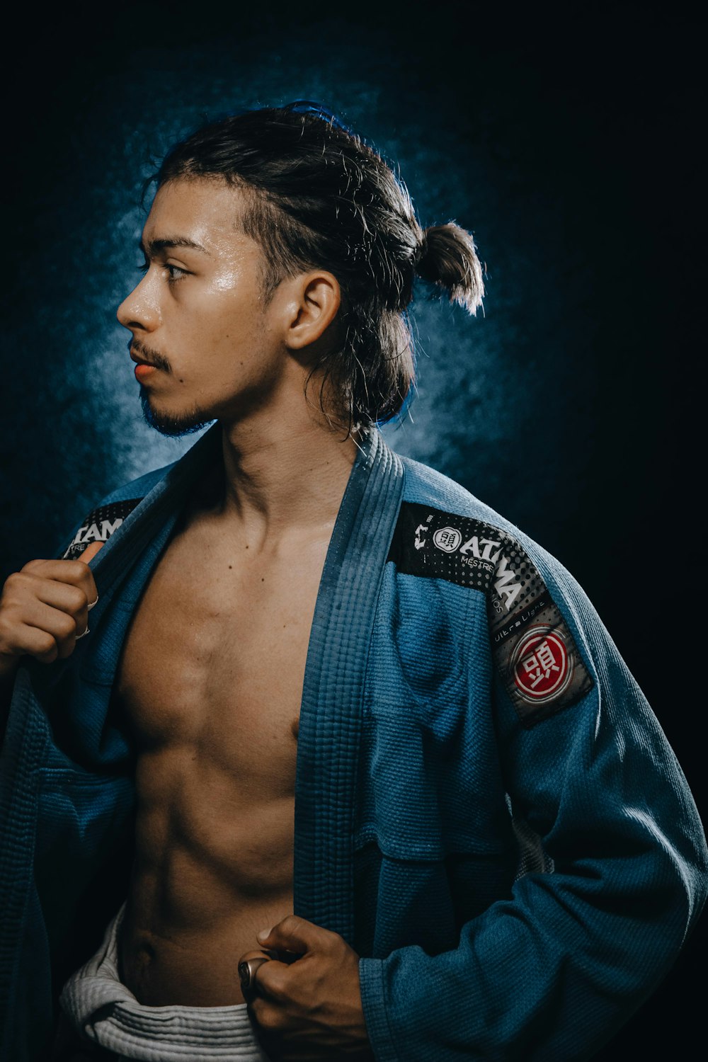 Un homme en kimono bleu pose pour une photo