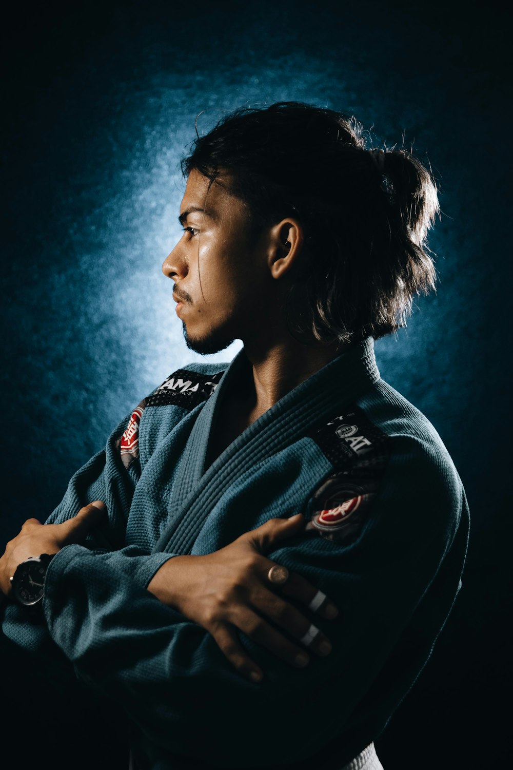 a woman in a blue kimono standing with her arms crossed