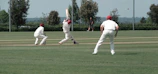 Cricket players celebrating a wicket with railway maroon jerseys