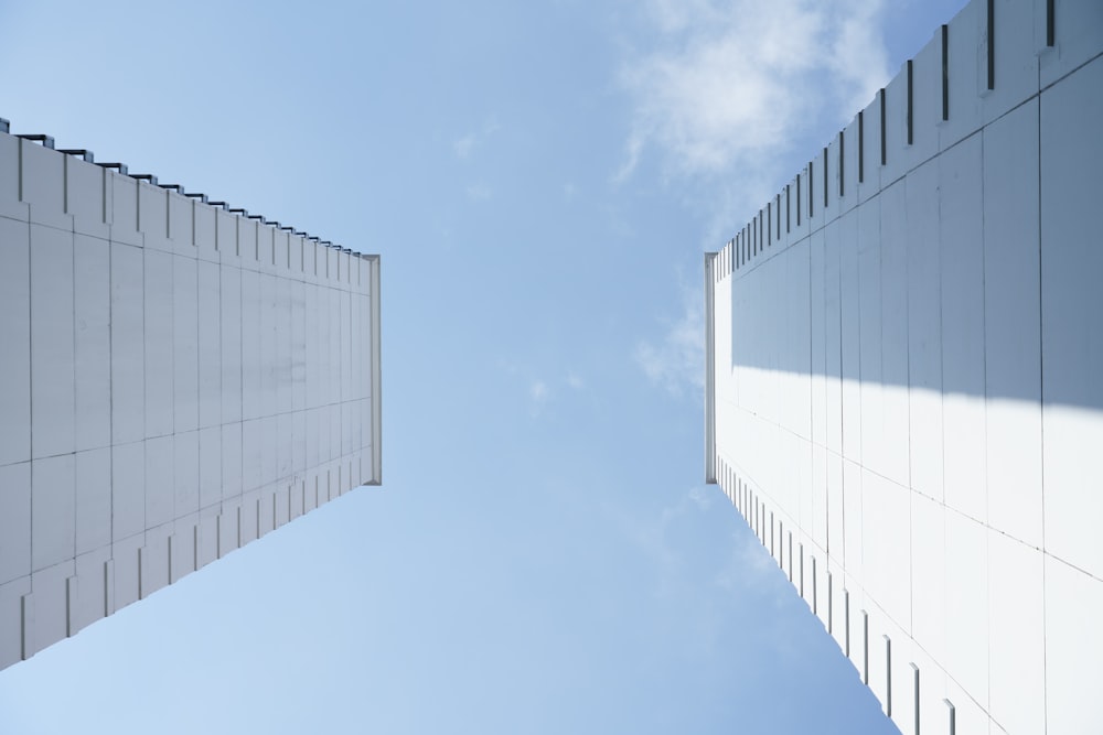 two tall white buildings against a blue sky