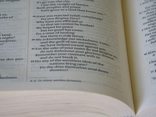 A close-up view of an open book displaying biblical text. The text includes verses numbered 19 through 22, discussing various religious themes. The pages are slightly curved, and the text is in a formal, serif font with a verse number reference.