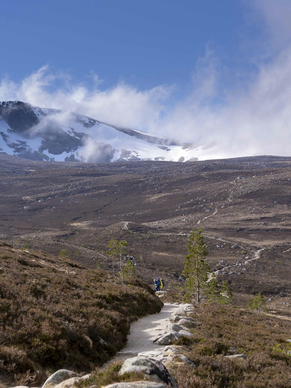 Dos personas caminando por un sendero en las montañas