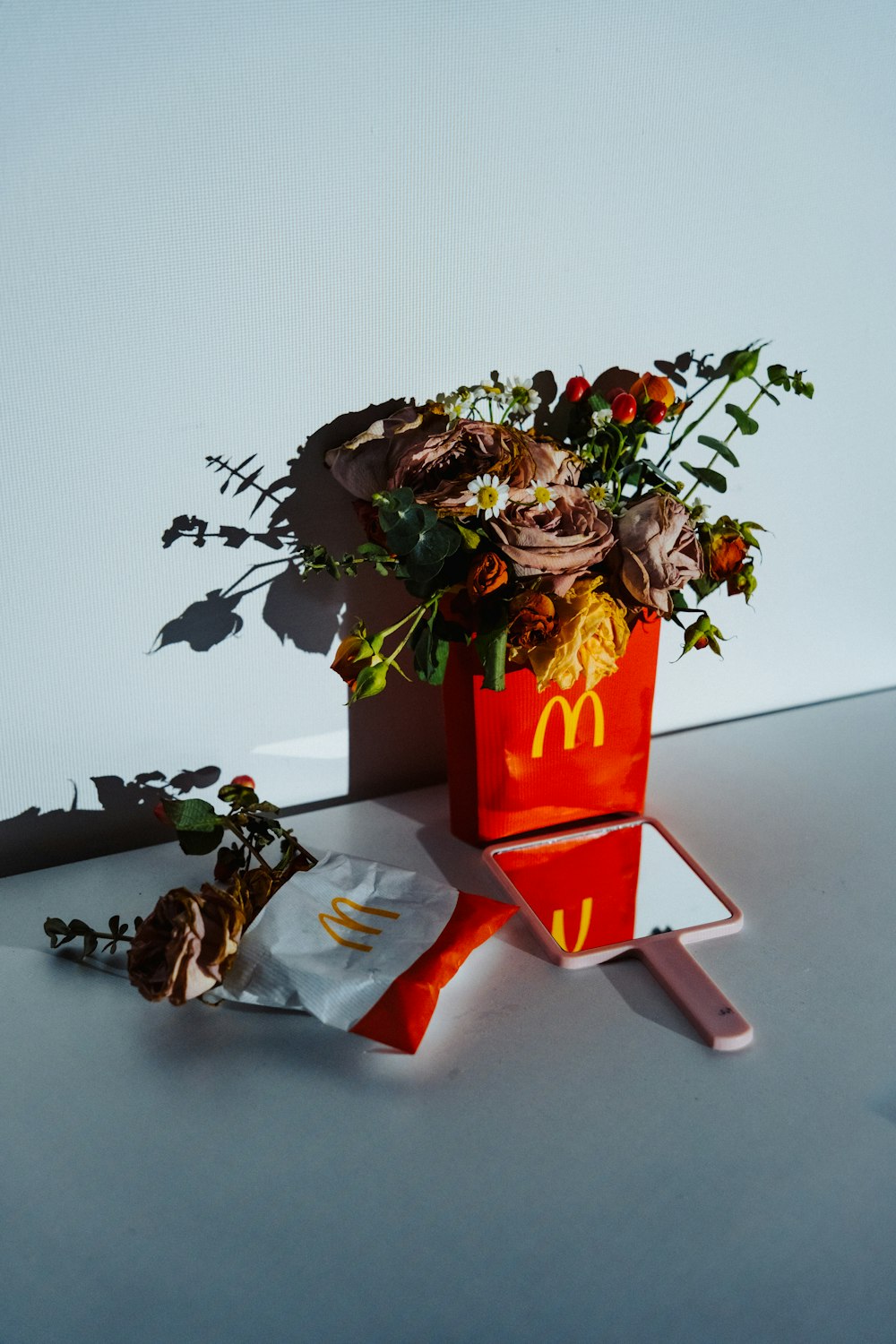 a bouquet of flowers in a mcdonald's bucket