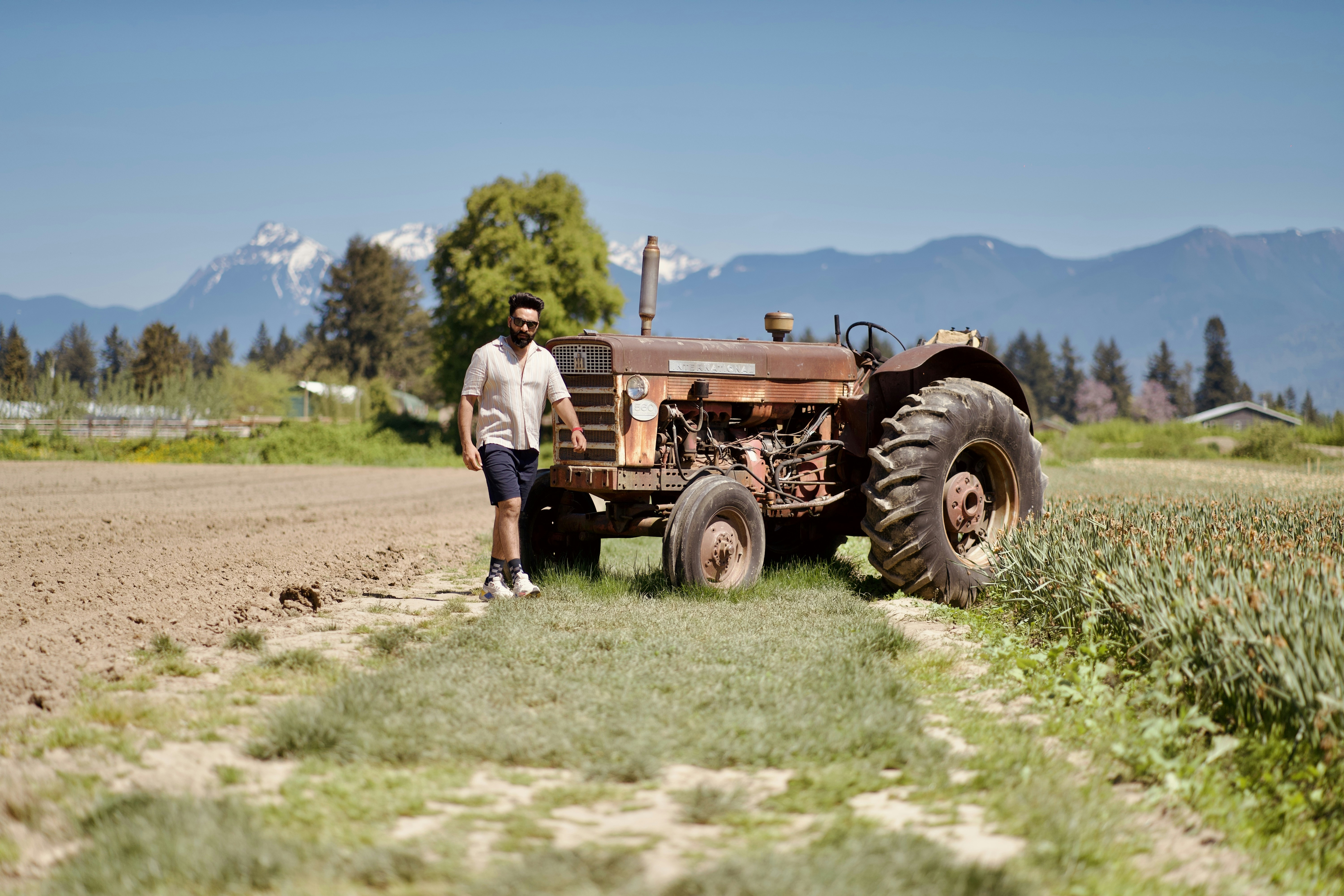 a man standing next to a tractor in a field
