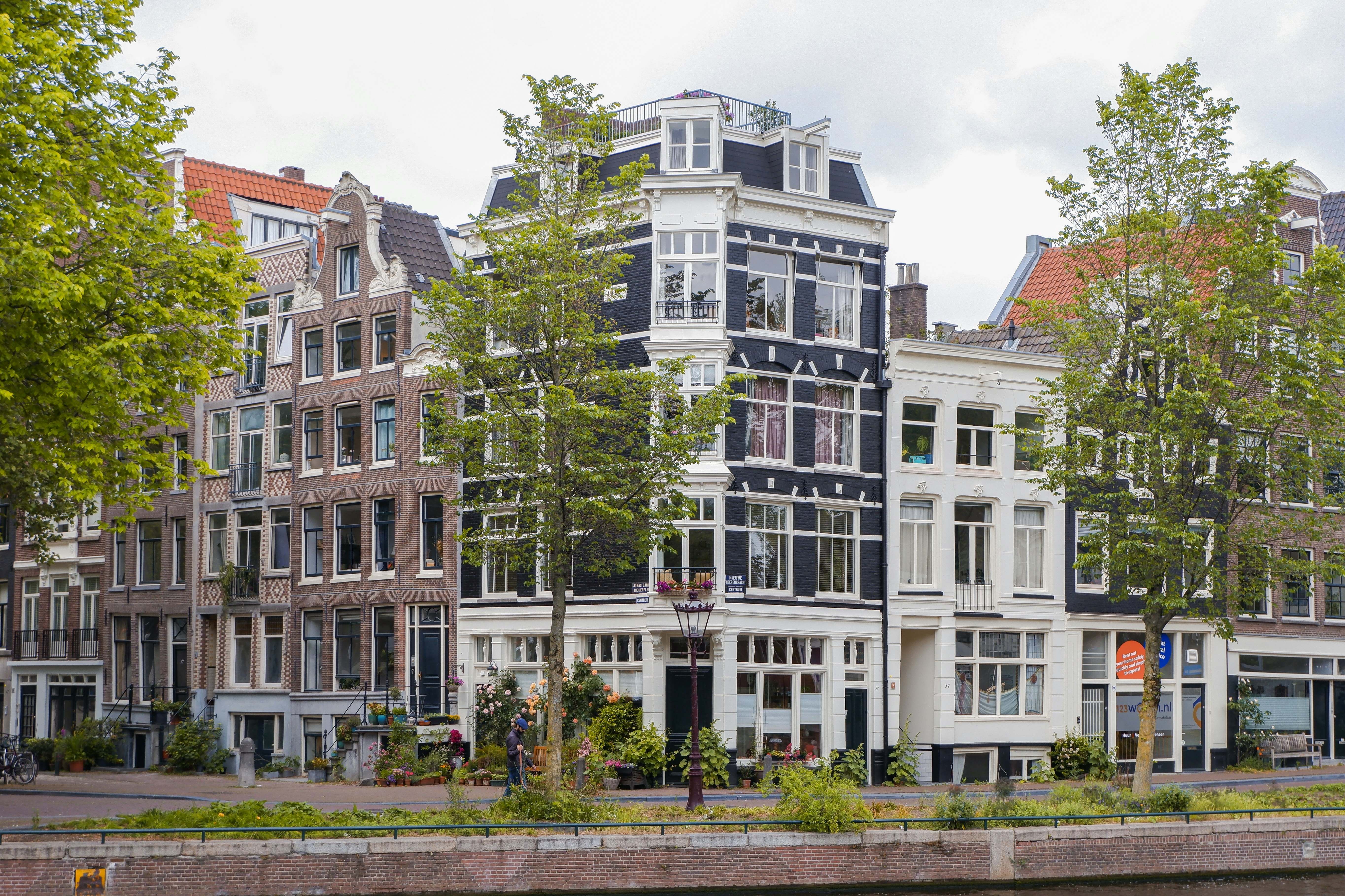 Hollanda'daki kira yardımı ve vergi avantajlarını simgeleyen geleneksel Hollanda evleri, hesap makinesi ve finansal dokümanlar.