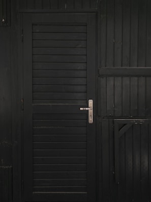 Technician reinforcing a wooden door with a steel blindage panel in a residential building.