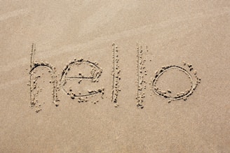 the word hello written in the sand on a beach