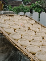 Rows of drying coconut sugar in traditional bamboo trays under the sun.