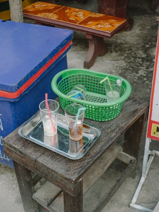 A rugged portable cooler filled with ice and drinks, set outdoors on a sunny day.