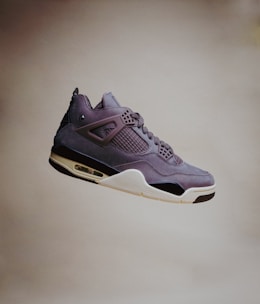 Photo of sleek, modern sneakers in mid-air against a clear sky background