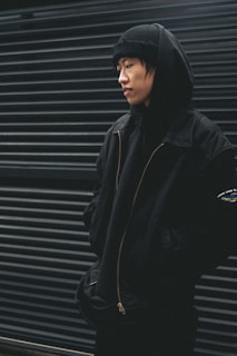 a young man standing in front of a garage door