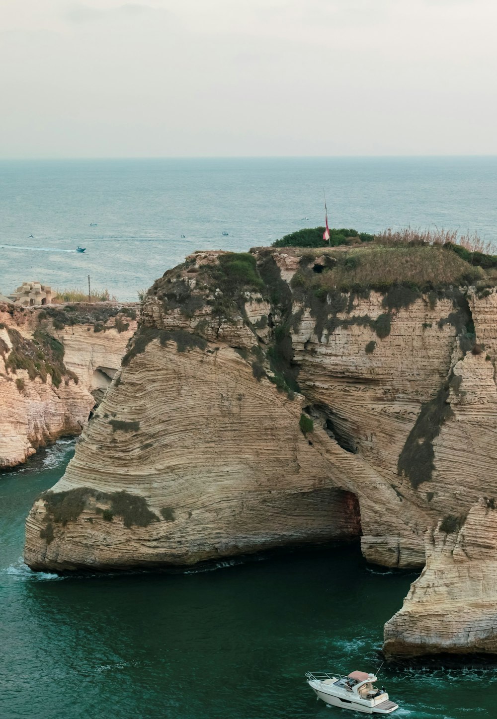 a boat is in the water near a cliff