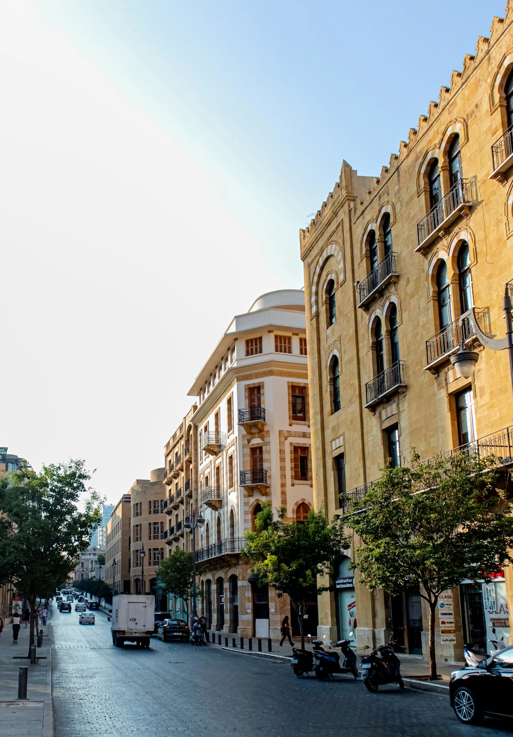 a city street lined with tall buildings and parked cars