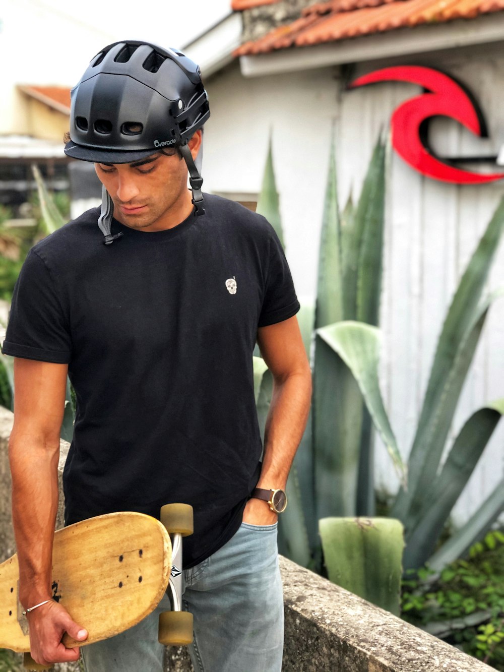 a man holding a skateboard in front of a house