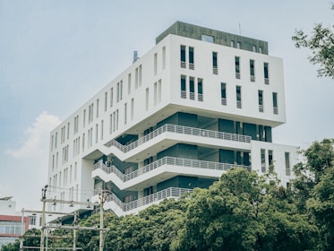 a tall white building with balconies on top of it