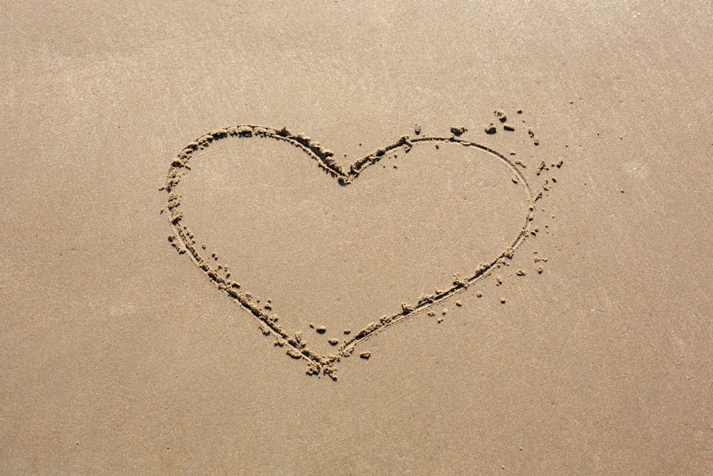 a heart drawn in the sand on a beach