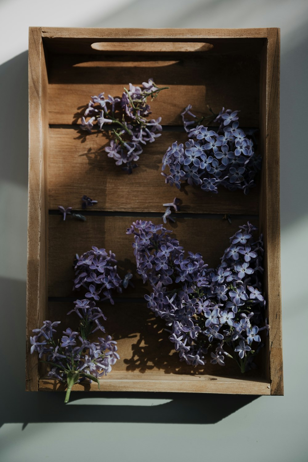 테이블 위에 보라색 꽃으로 채워진 나무 상자