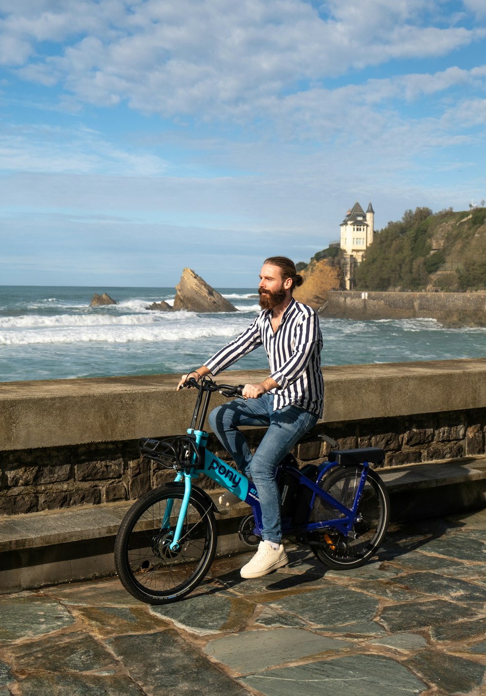 a man sitting on a bike next to the ocean