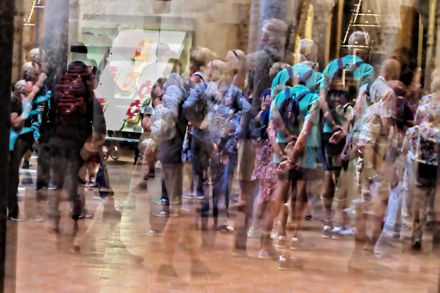 A blurred image of a crowded office with people looking worried and stressed.