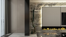 A modern, sleek interior with a vertical, ribbed panel integrated into a decorative wall. Beneath the panel, a linear gas fireplace emits artificial flames. The wall features a marble texture with a mix of dark and light tones. To the left, a section of softly pleated gray curtains is visible, adding an element of elegance.