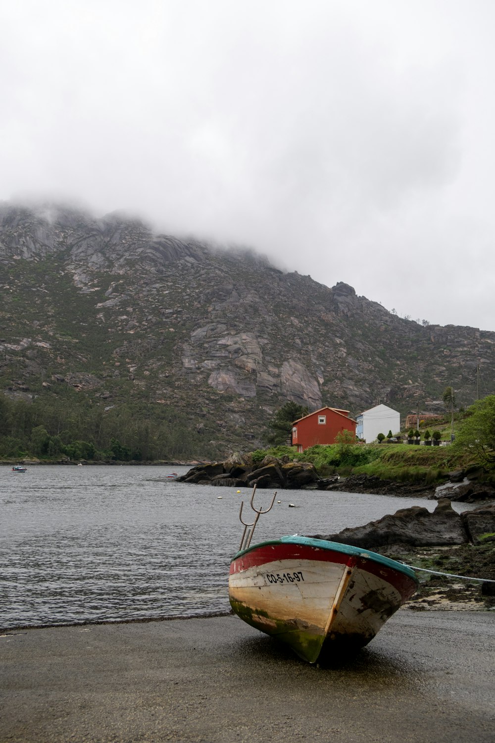 a boat sitting on the shore of a lake