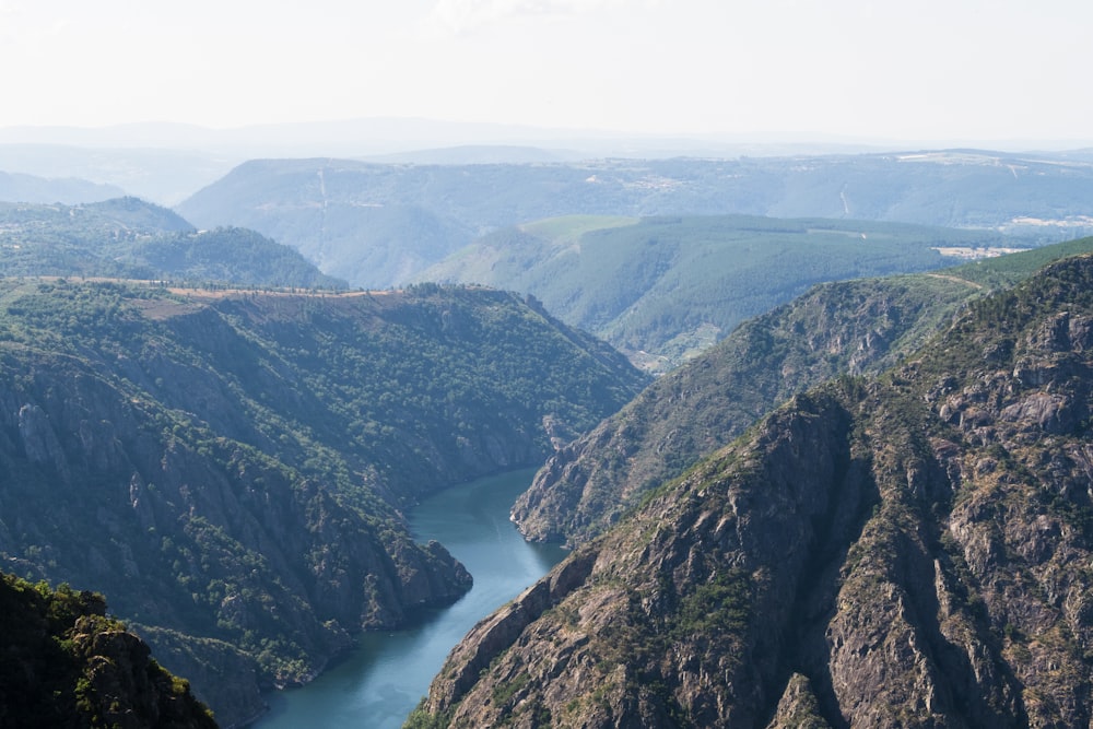 a river flowing through a valley surrounded by mountains