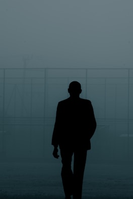 A minimalist frame of a model walking through a foggy street, shot in monochrome.