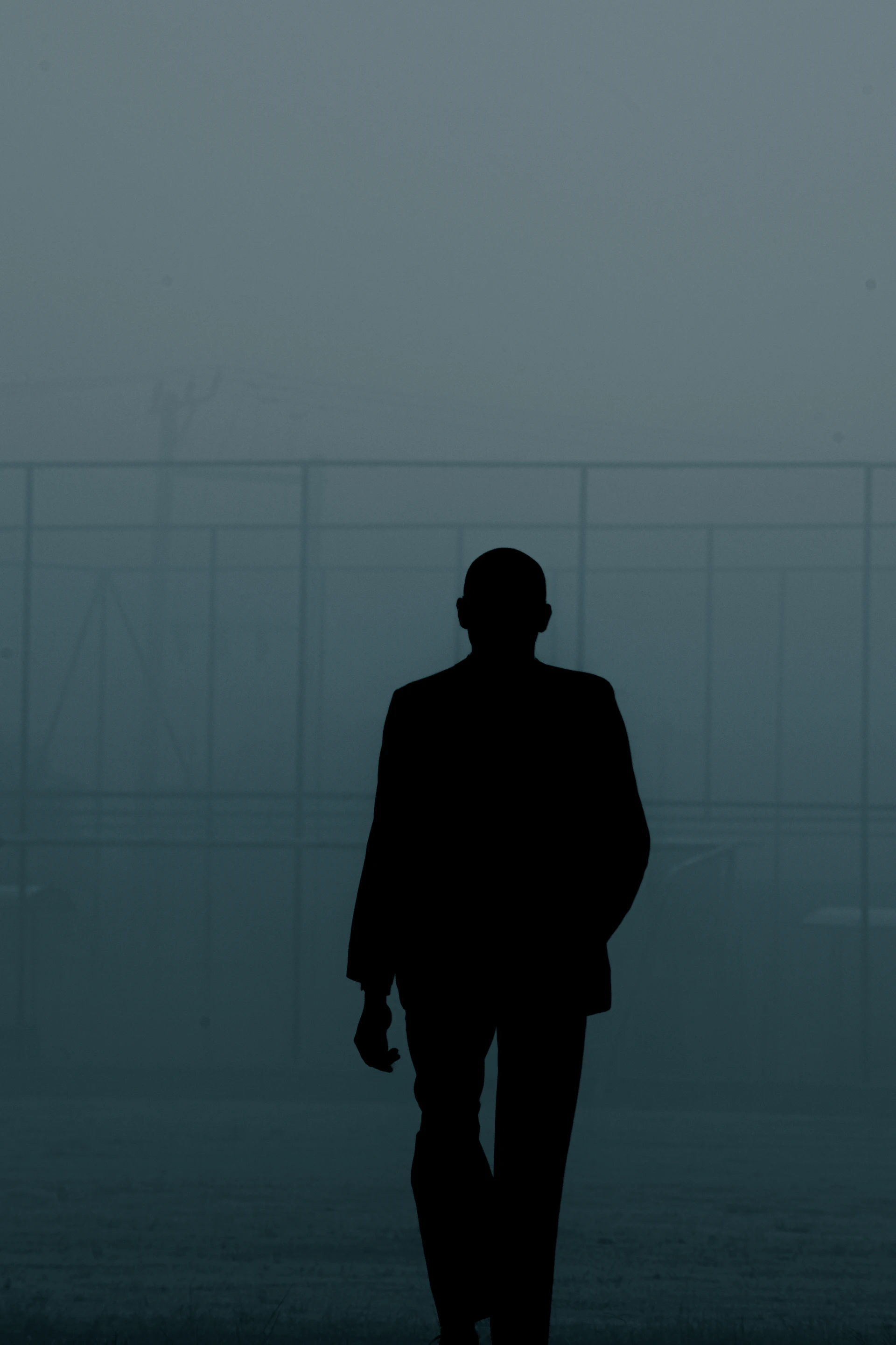 Silhouette of a person standing in fog, monochrome