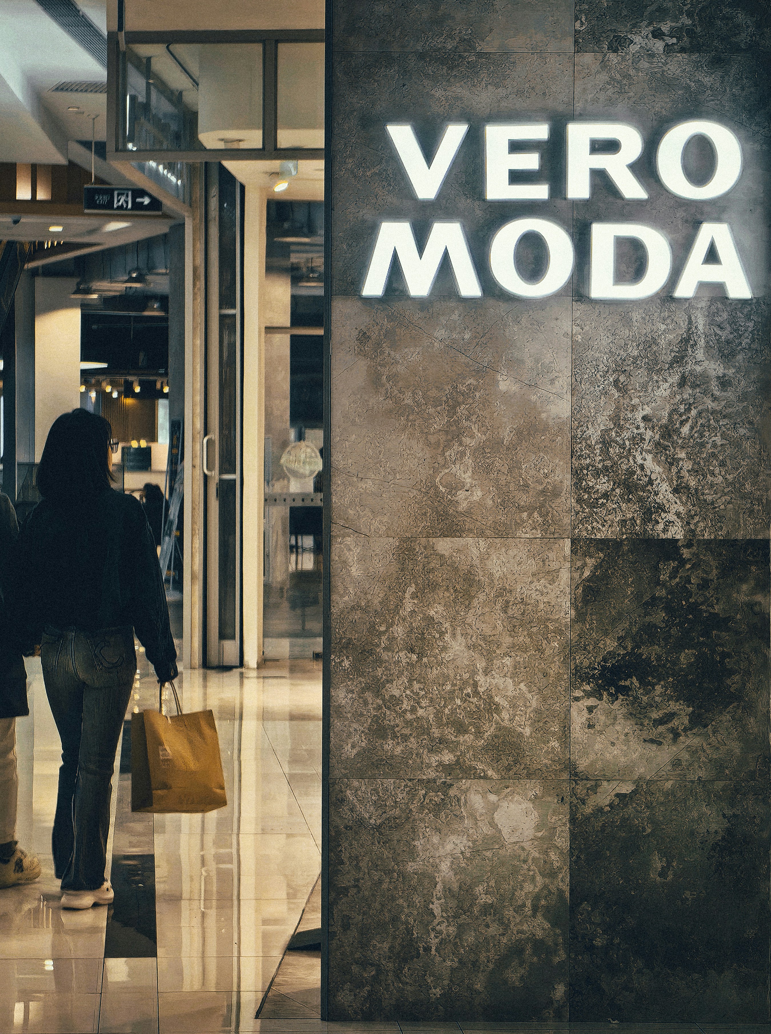 a woman walking past a vero modda store