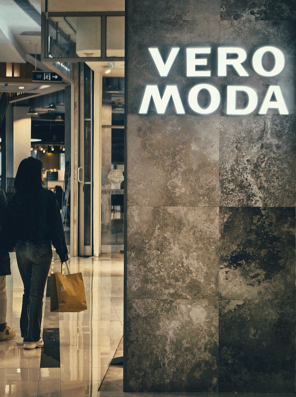 a woman walking past a vero modda store