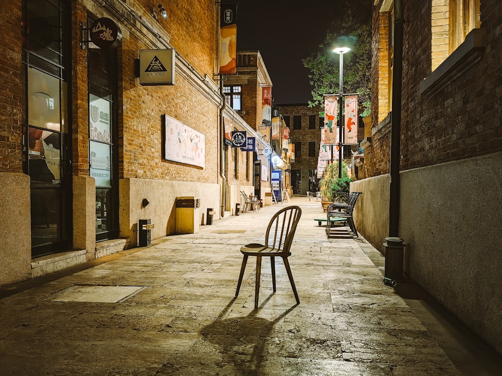 a chair sitting on a sidewalk next to a building