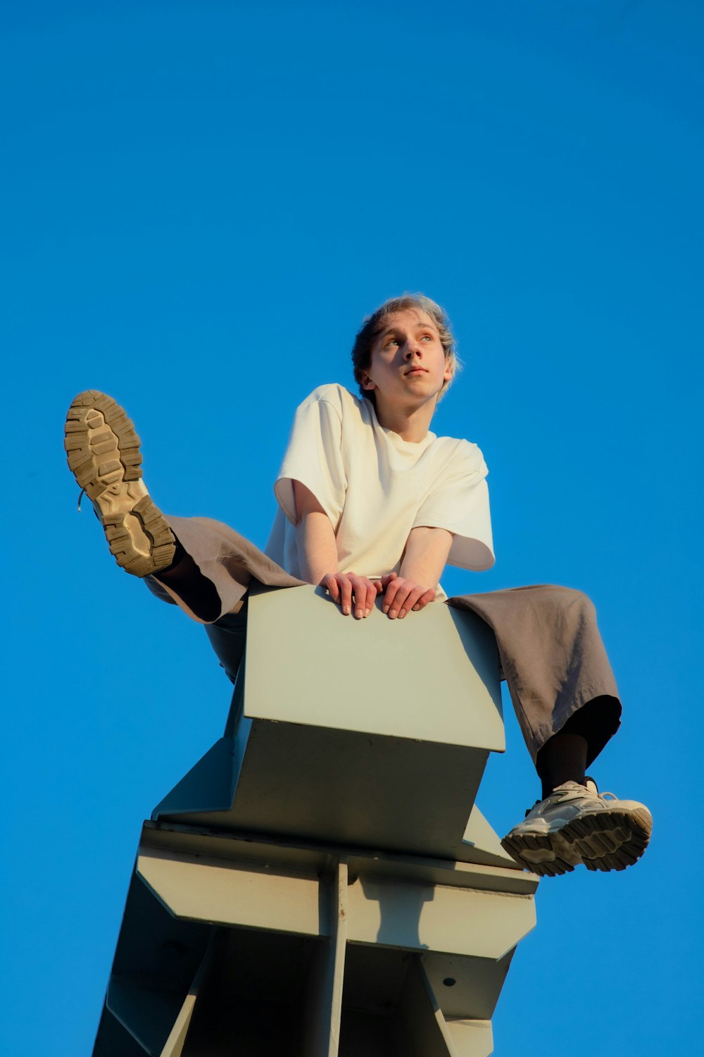 a man sitting on top of a metal structure