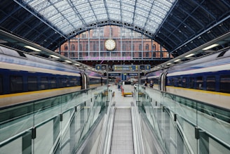 a train traveling through a train station next to a clock