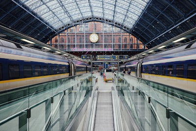 a train traveling through a train station next to a clock