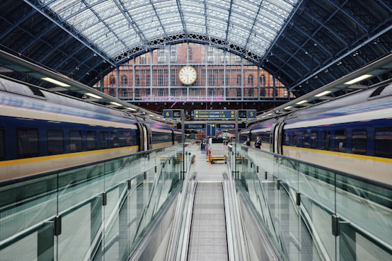 a train traveling through a train station next to a clock