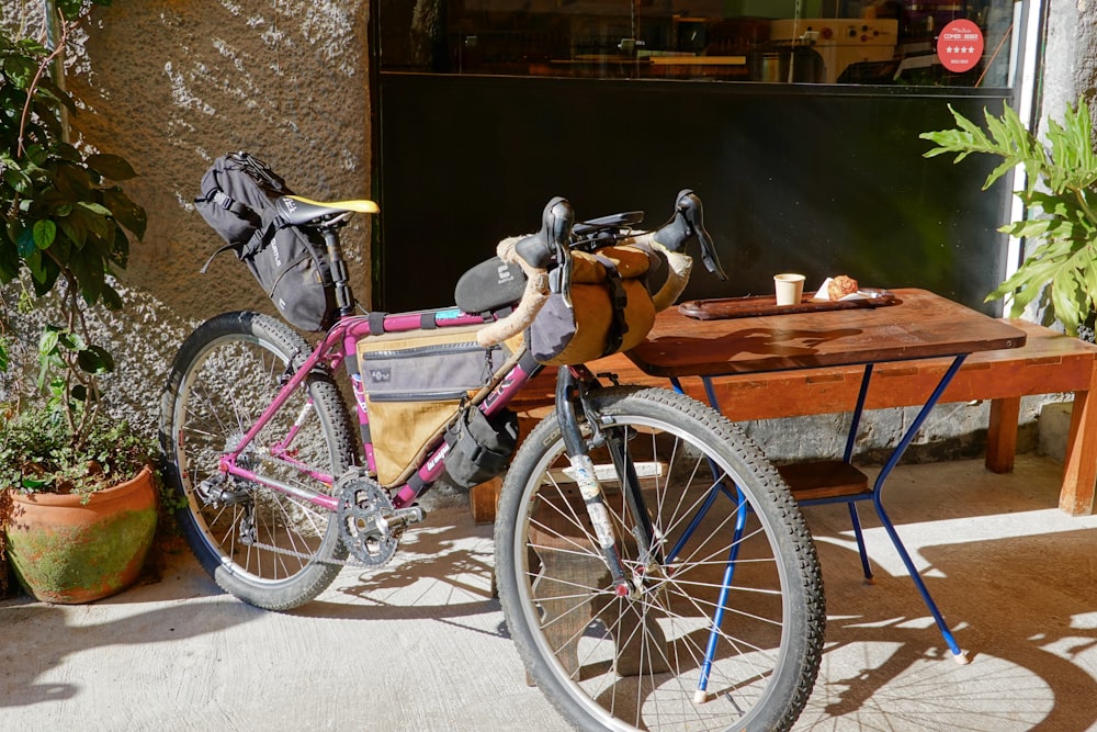a bicycle parked next to a wooden table