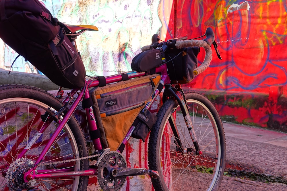 a bicycle parked next to a wall with graffiti on it