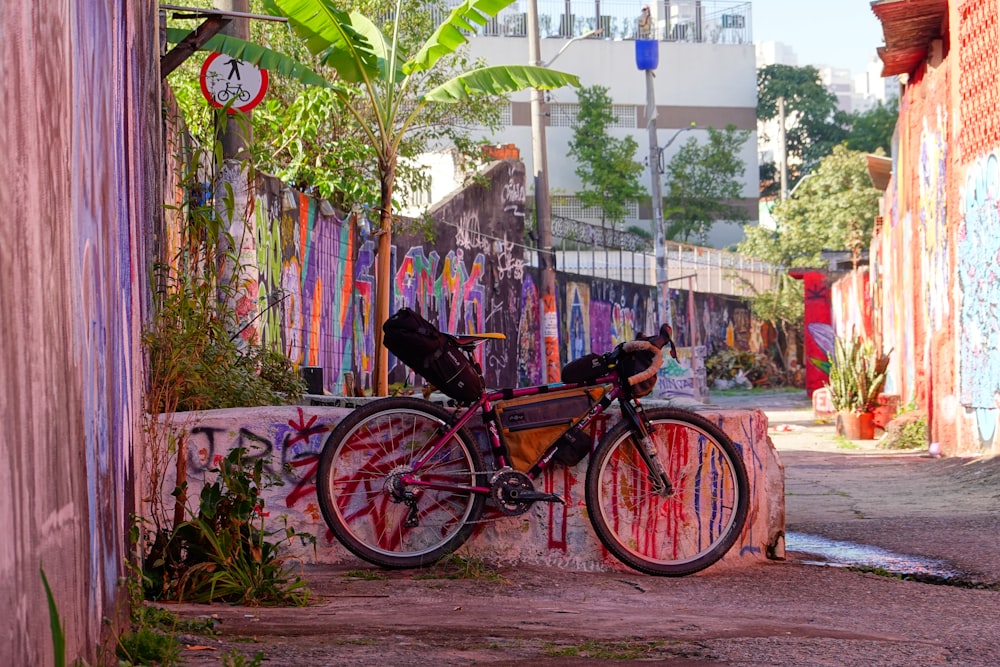 a bike parked next to a wall covered in graffiti