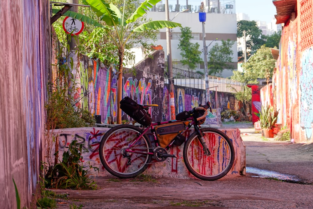uma bicicleta estacionada ao lado de um muro coberto de pichações
