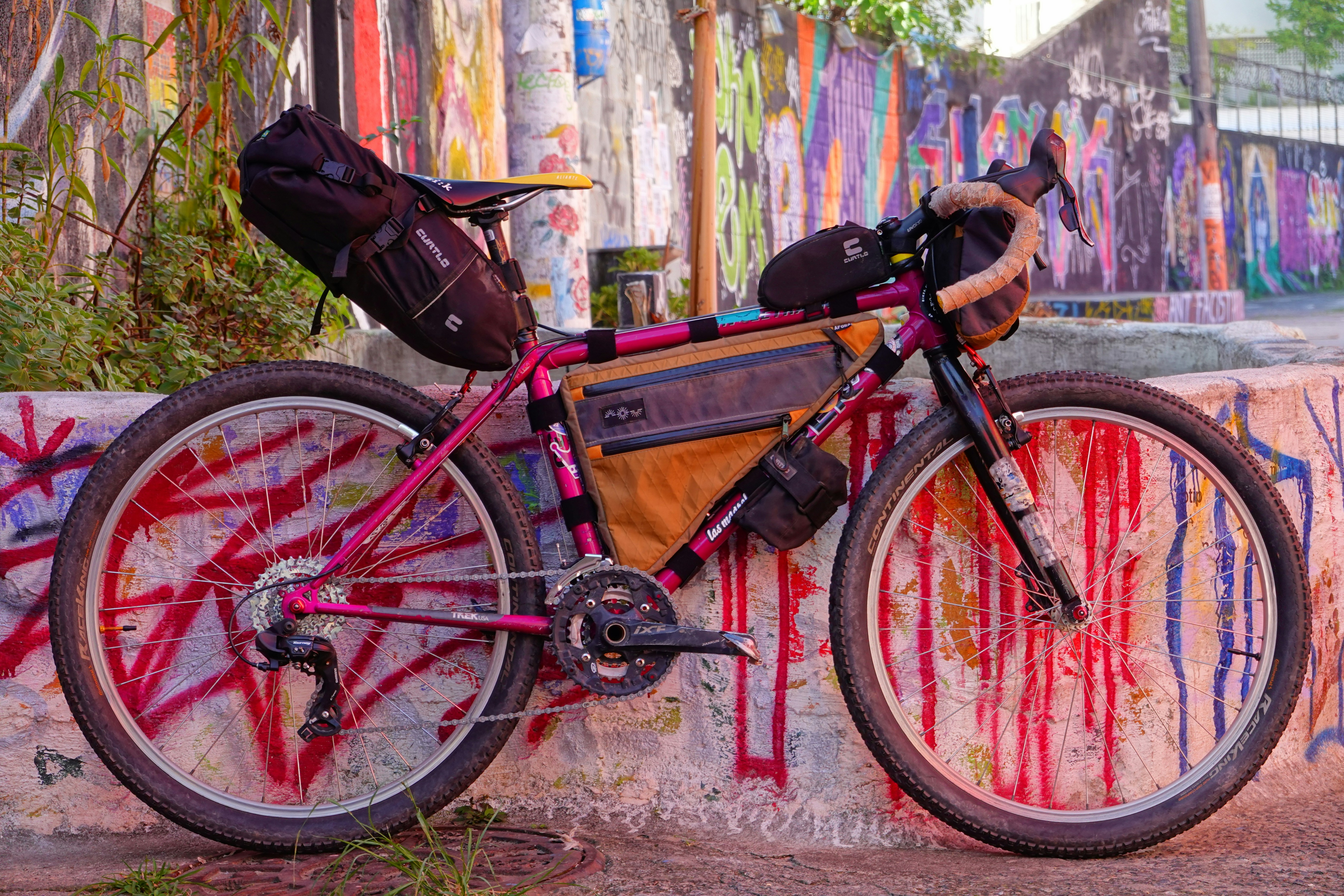 a bicycle parked against a wall covered in graffiti