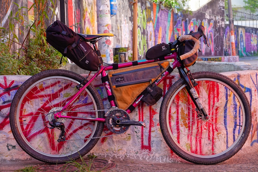 a bicycle parked against a wall covered in graffiti