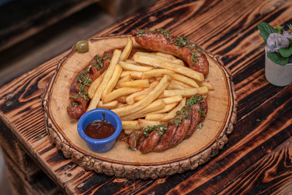 a wooden table topped with a plate of french fries and a hot dog