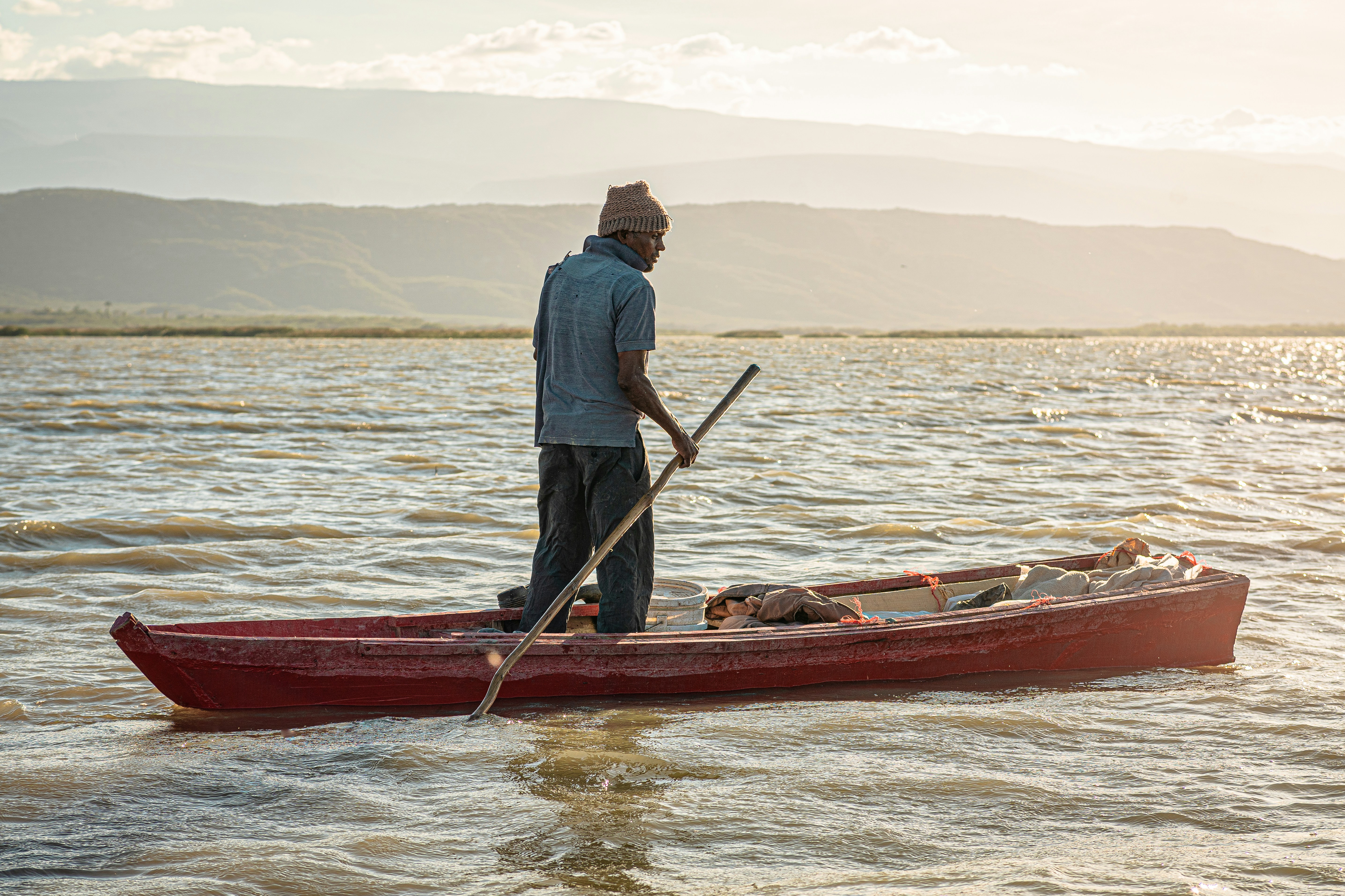 A man standing in a red canoe with a dog photo Free República