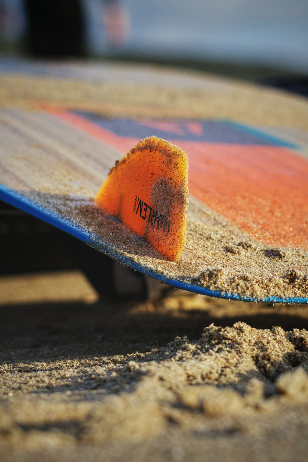 a close up of a surfboard with sand on it