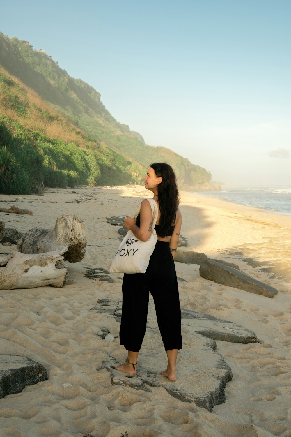 a woman standing on top of a sandy beach