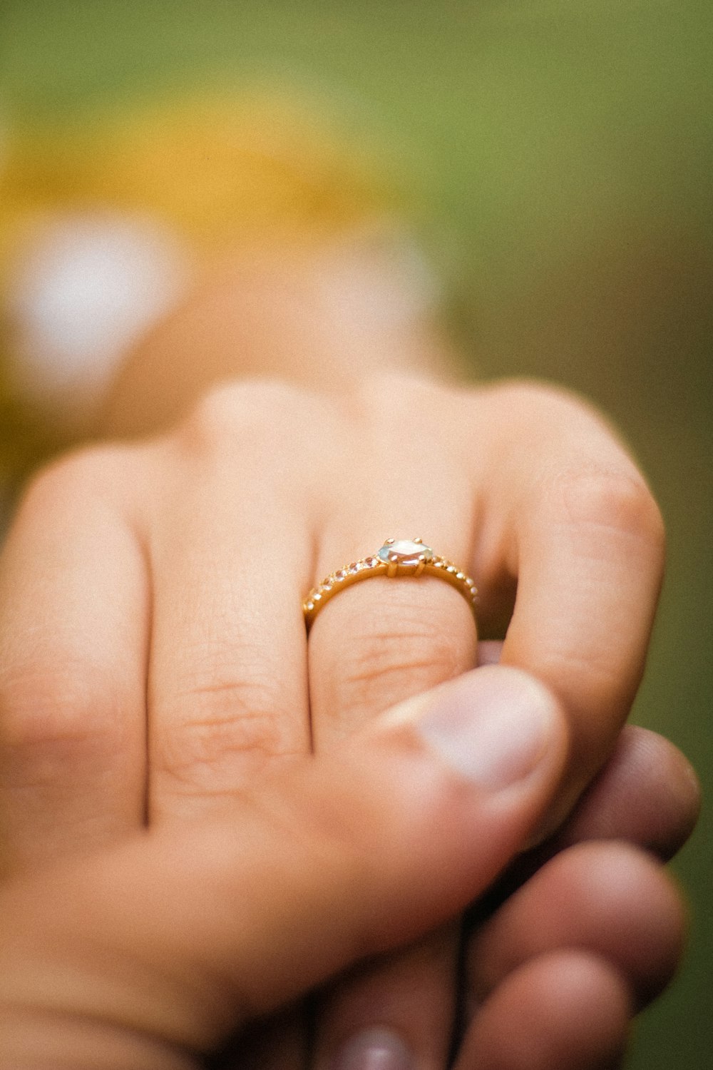 a close up of a person holding a wedding ring