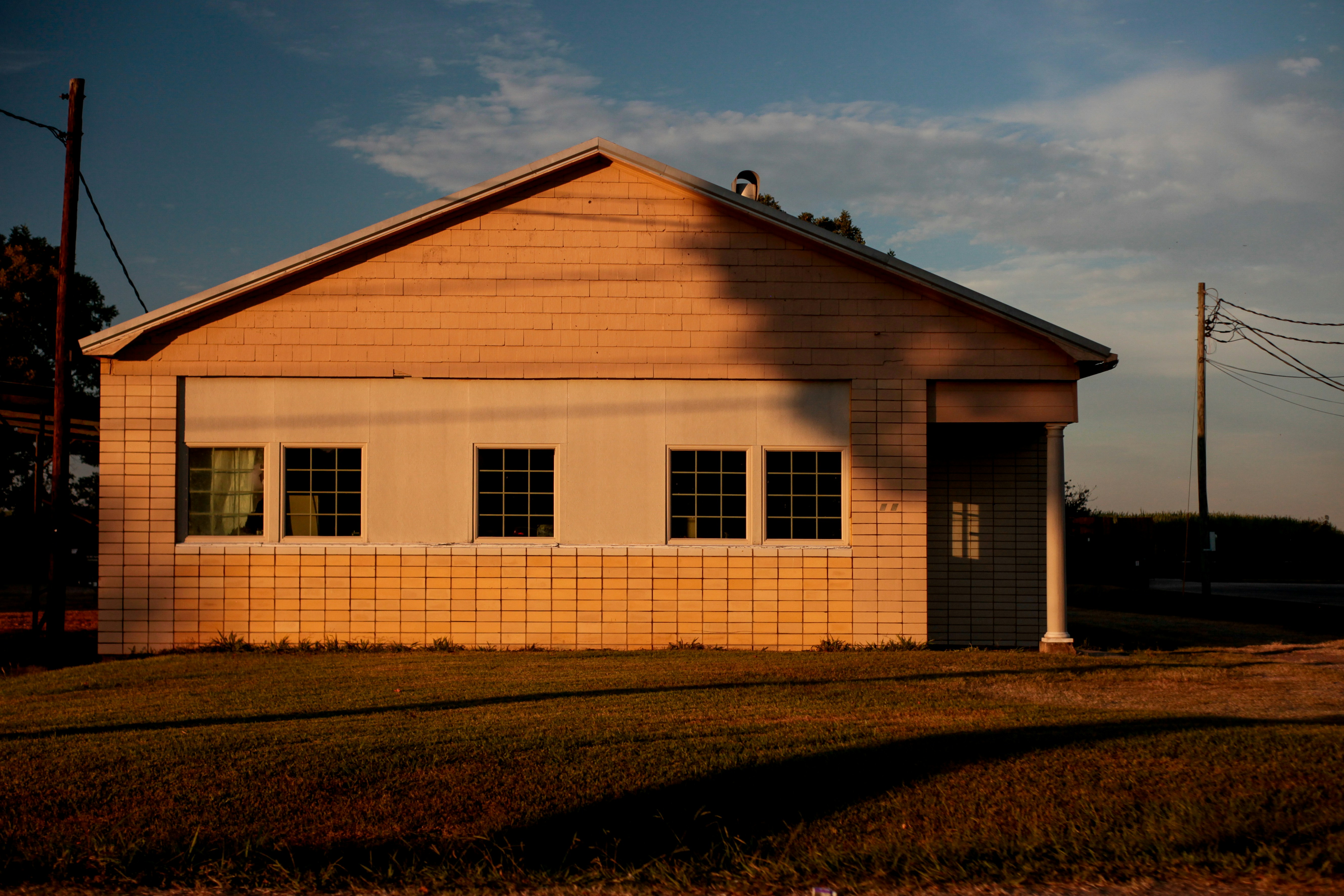 a small white house sitting in the middle of a field