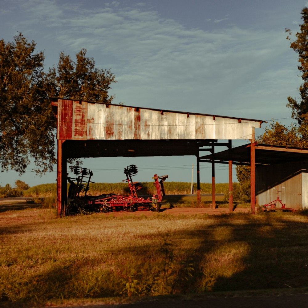 un tractor estacionado bajo una estructura cubierta en un campo