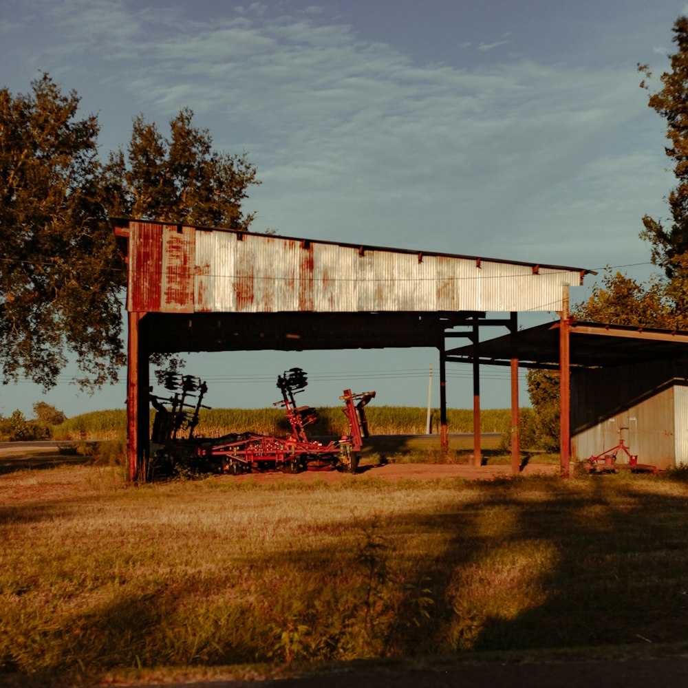 a tractor parked under a covered structure in a field